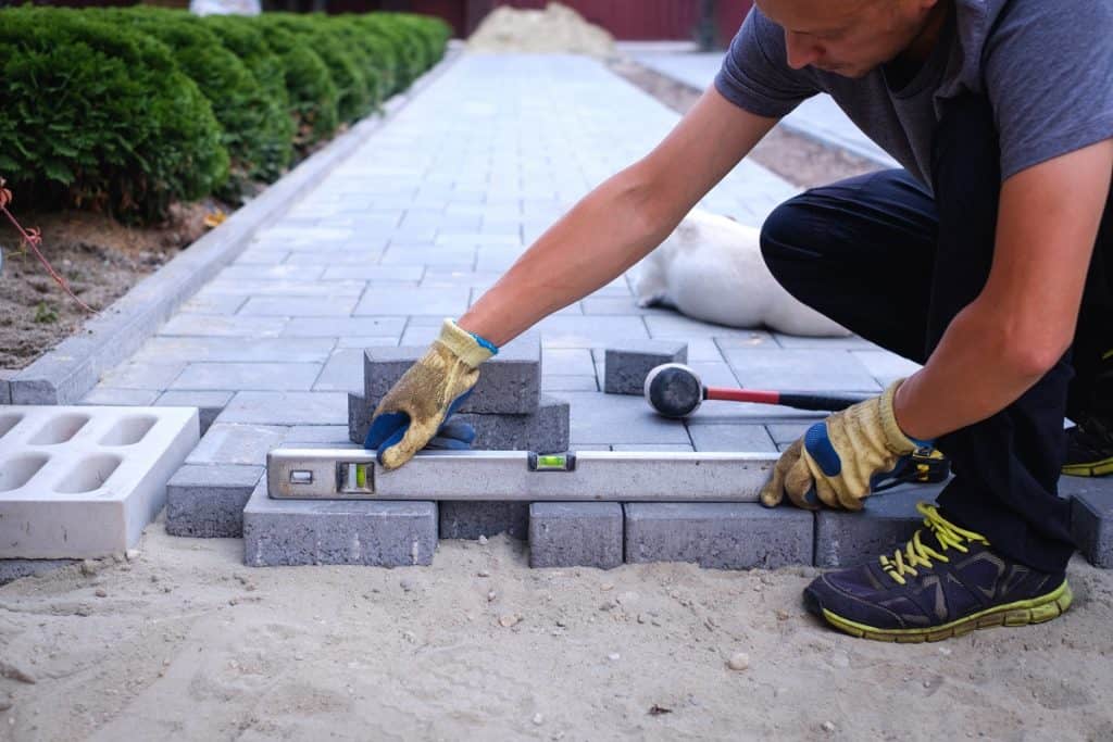 The,Master,In,Yellow,Gloves,Lays,Paving,Stones,In,Layers.